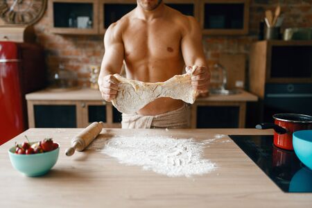 Athletic husband in underwear cooking on kitchenの写真素材