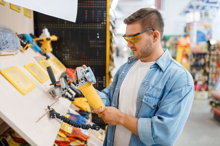 Buyer holding edging machine in hardware store