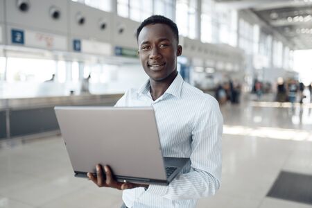Businessman working on laptop in car showroom