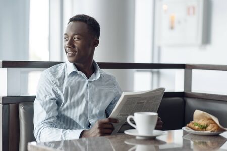 Ebony businessman having lunch in office cafeの写真素材