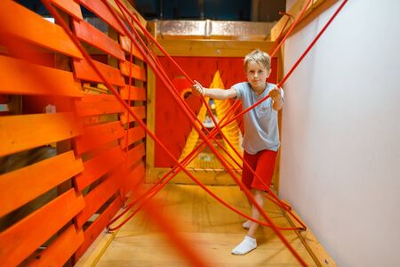 Little boy playing in rope labyrinth, playground