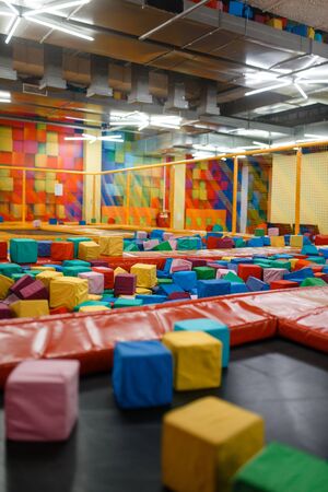 Kids trampoline and soft cubes on playground in entertainment center, nobody. Play area for children indoors, playroomの写真素材