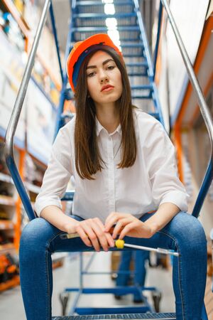Female customer sitting on stairs, hardware storeの写真素材