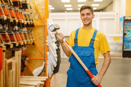 Builder choosing sledgehammer in hardware storeの写真素材