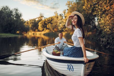 Pretty lady poses in boat on quiet lakeの写真素材
