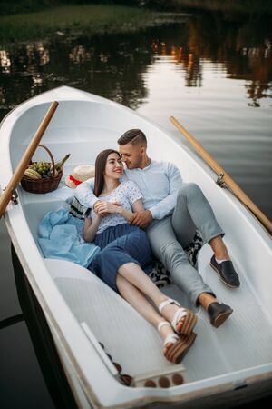 Love couple lying in a boat and dreamingの写真素材