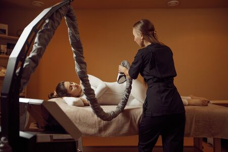 Masseur with vibrating massager, spa salonの写真素材