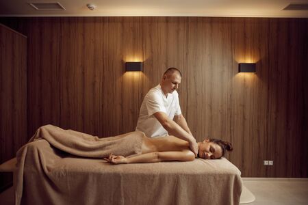 Male masseur pampering neck to young womanの写真素材