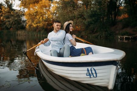 Love couple hugs in a boat on quiet lakeの写真素材