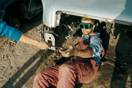 Male mechanic in welding glasses on car junkyardの写真素材