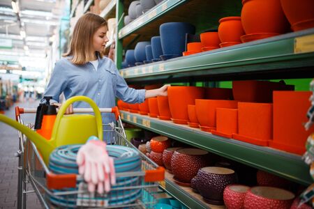 Customer at shelf with pots, shop for gardeningの写真素材