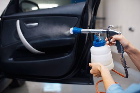 Female washer cleans automobile interior, car washの写真素材