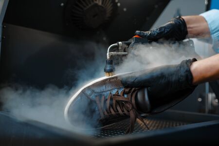Shoemaker processes the shoes on special machineの写真素材