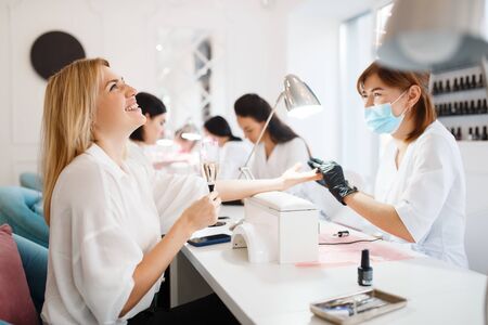 Group of women on manicure procedure, beauty salon
