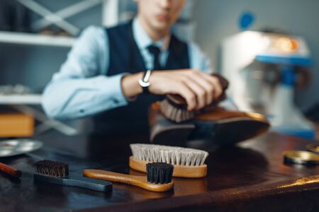 Shoemaker wipes black shoe polish, footwear repairの写真素材