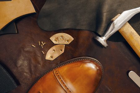 Shoemaker workplace, footwear repair service. Shoemaking workshop, repaired boots and bootmaker...