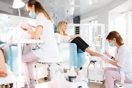Girlfriends on pedicure procedure in beauty salonの写真素材
