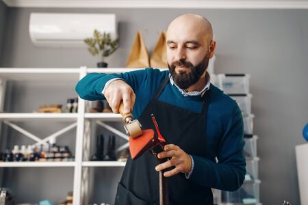 Shoemaker repairing shoe, footwear repair service