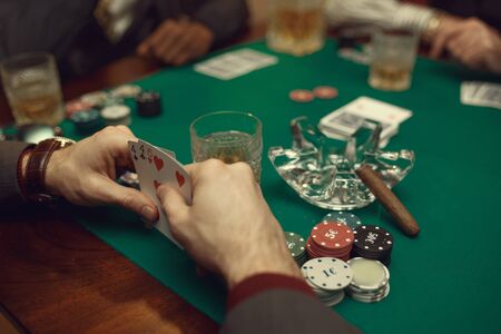 Poker players sitting at the table with cards and chips in casino. Games of chance addiction, gambling house,の写真素材