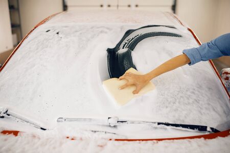 Female washer wipes the automobile windshield
