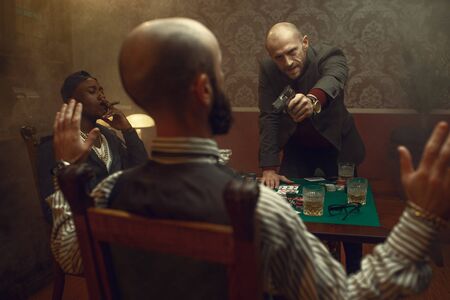 Poker player with gun wants to take the winningsの写真素材