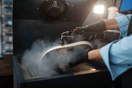 Shoemaker processes the shoes on special machineの写真素材