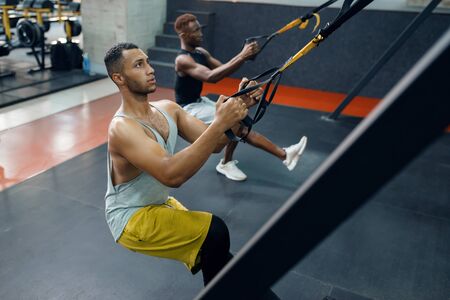 Two athletes at exercise machine, training in gymの写真素材