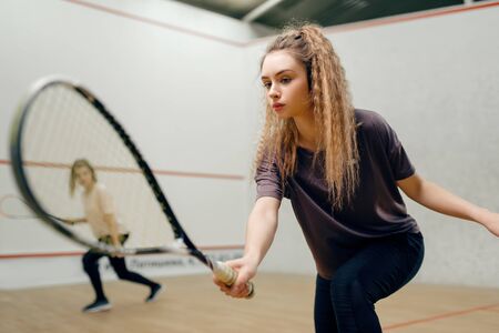 Two players with squash racket playing on courtの写真素材