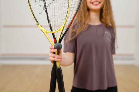 Female person shows squash racket and ballの写真素材