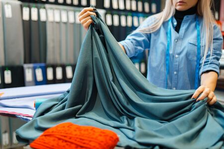 Seamstress works with fabric, textile workshopの写真素材