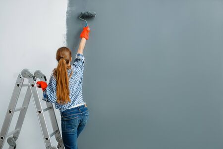 Female house painter paints walls indoorの写真素材