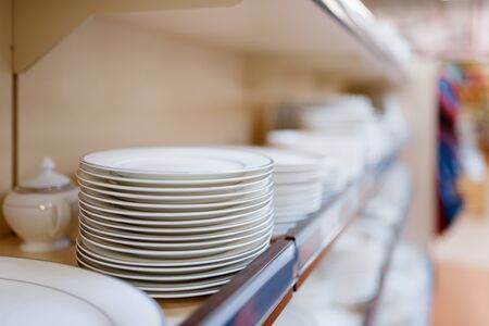White plates on the shelf closeup, houseware store, nobody. Home goods in market, kitchenware supply shop productsの写真素材