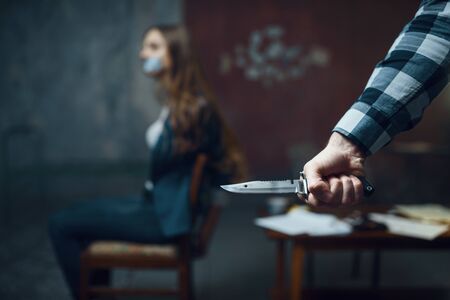 Maniac kidnapper with knife, scared female victimの写真素材