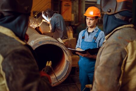 Master and crew of welders works on factory