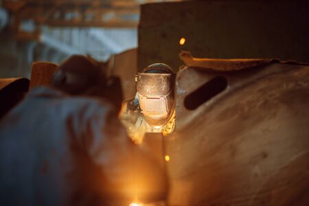 Two welder in masks works with metal, welding