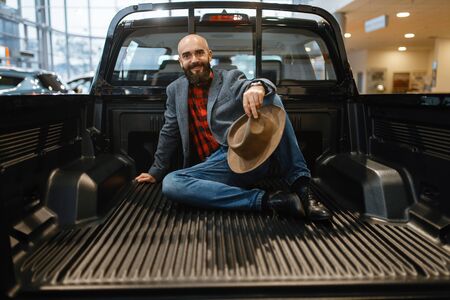 Smiling man poses in the back of new pickup truckの写真素材