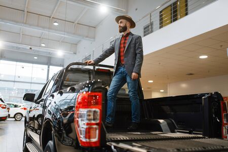 Man standing in the back of new pickup truck