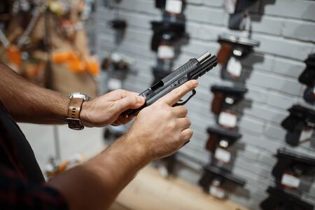 Man choosing new handgun in gun shop