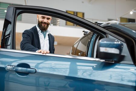 Man at the opened door of new automobileの写真素材