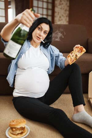 Pregnant woman smoking and drinks alcoholの写真素材