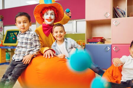 Funny clown with little boy in kindergarten