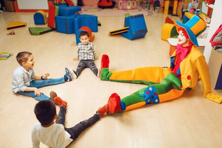 Funny clown play with boys in kindergartenの写真素材
