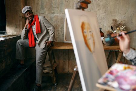 Female painter with brush draws male modelの写真素材