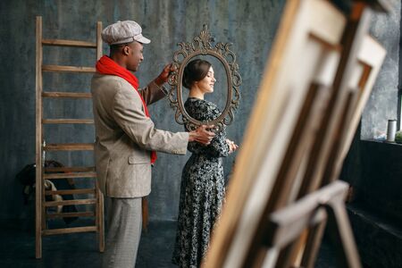 Portrait painter holds frame, female modelの写真素材