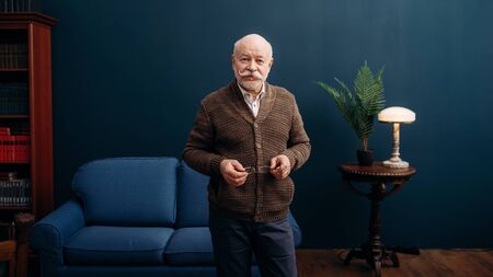 Representative elderly man poses in home office