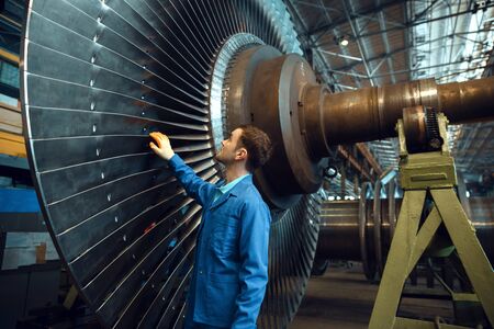 Engineer checks turbine impeller vanes, factoryの写真素材
