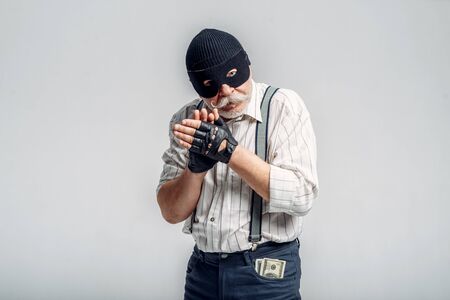 Elderly robber in mask isolated on grey backgroundの写真素材