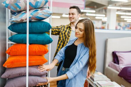 Love couple holds pillows in furniture storeの写真素材
