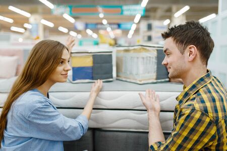 Couple choosing mattress in furniture storeの写真素材