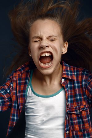 Little girl shouting in studio, developing hairの写真素材
